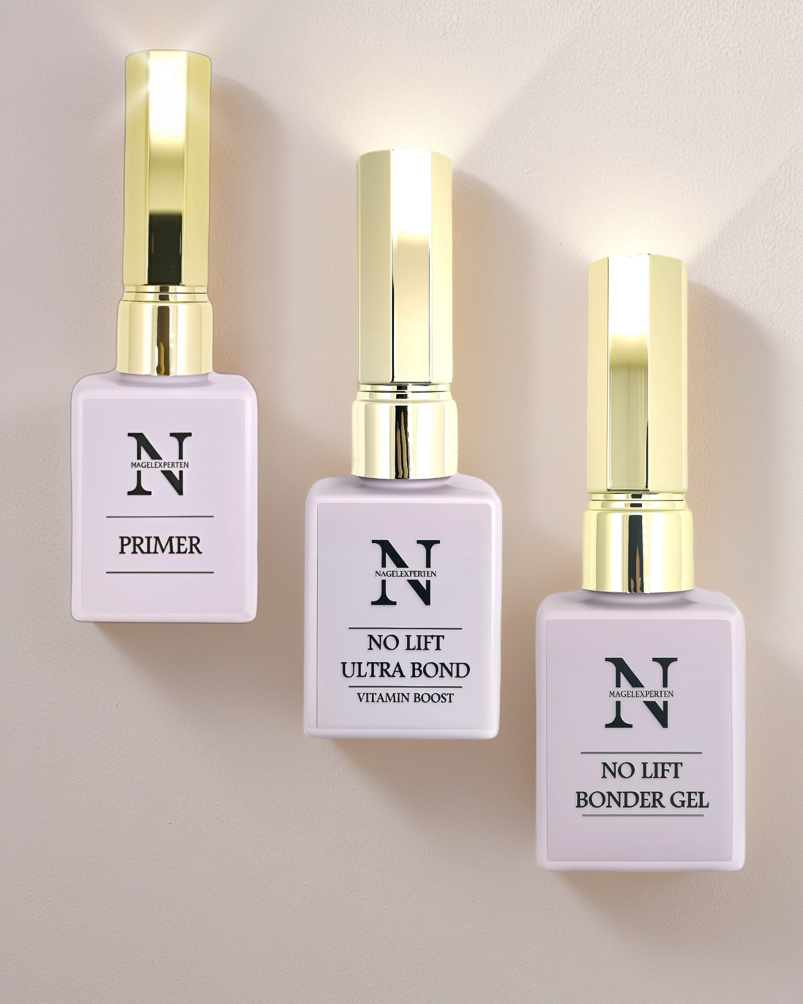 Tre lila nagellacksflaskor med guldiga lock innehållande nagel prep för gelenaglar.