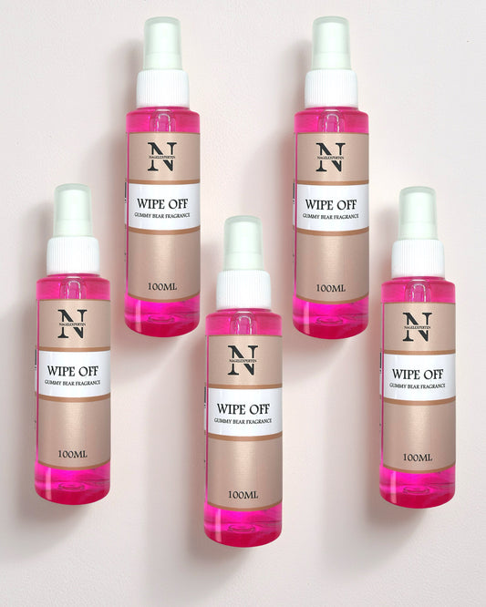 Fem sprayflaskor som ligger på ett bord innehållande rosa vätska med cleanser för rengöring av naglar.