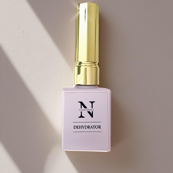 Lila flaska med guldig kork som glänser, innehållande dehydrator för avfettning av naglar. Bakgrunden är beige med skuggor från fönster.