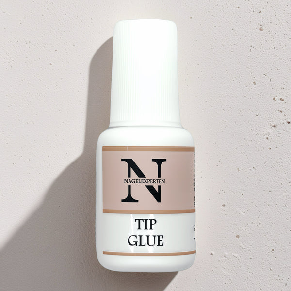 Flaska med extra starkt och snabbtorkande nagellim med pensel – perfekt för att limma nageltippar och dekorationer. 7,5 ml.